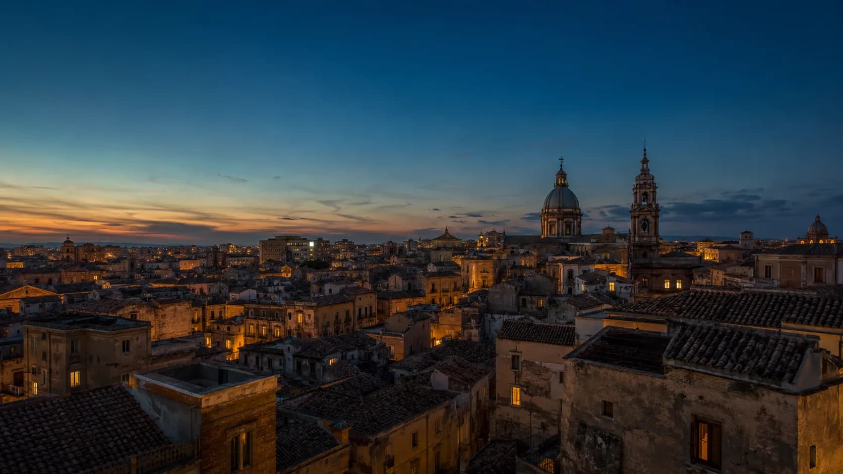 I tetti di Palermo all'ora blu, tra cupole barocche e finestre illuminate al tramonto