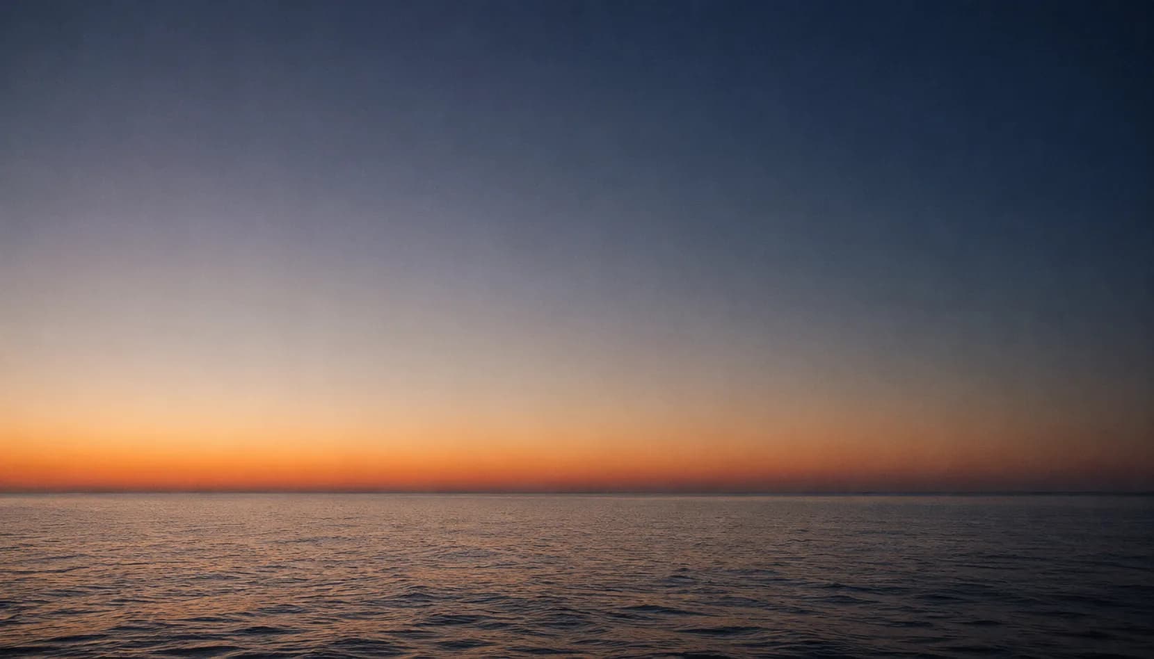 Il mare di Sicilia all'imbrunire, orizzonte tra blu profondo e ambra